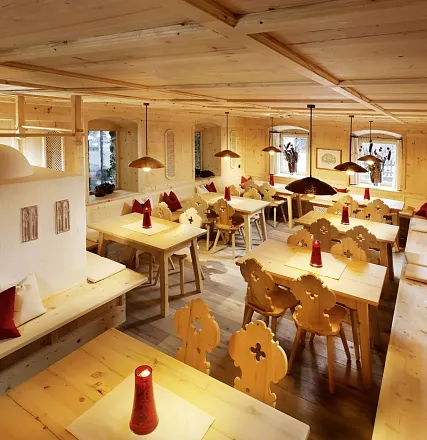 Ein gemütliches Restaurant im rustikalen Stil mit Holzmöbeln und dekorativen Stoffservietten. Holztische und -stühle schaffen eine warme Atmosphäre.